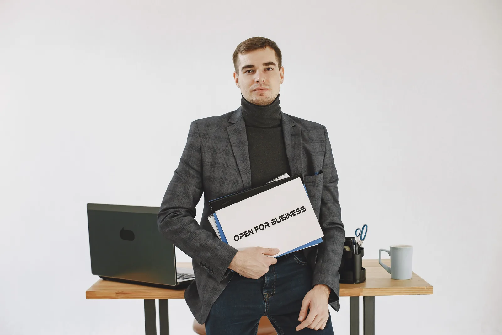 Businessman in corporate attire holding open for business sign, ready to work. Talent management agency startup costs, reviewed without the sales pitch